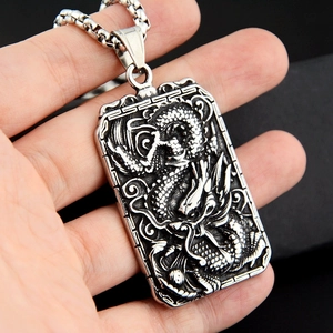 Détail macro du pendentif carré en acier inoxydable argenté avec relief de dragon