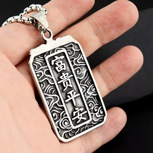 Vue rapprochée du pendentif dragon en argent avec relief Fu Gui Ping An et motifs nuages