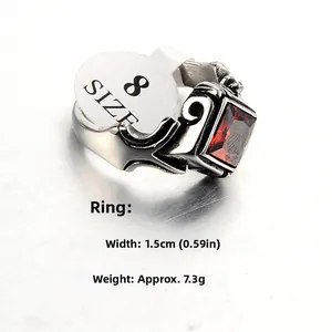 Macro shot of punk style stainless steel ring with red stone and size label details
