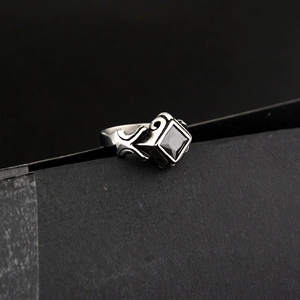 Macro shot of punk style stainless steel ring with square black gemstone and relief texture