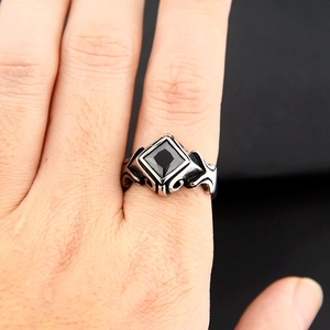 Macro detail of gothic punk ring featuring a black rhombus gemstone on stainless steel