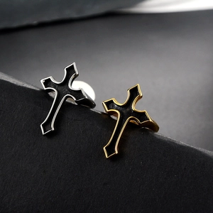 Close-up of gold and silver gothic cross rings with black enamel on stone steps