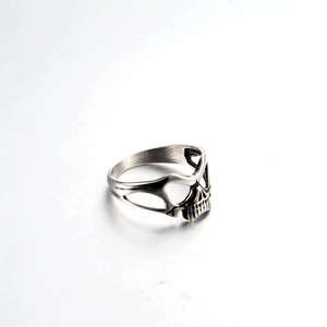 Detailed close-up of a punk-style stainless steel skull ring with vintage silver finish