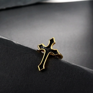 Close-up of gothic punk cross ring with black enamel inlay and gold-plated steel finish
