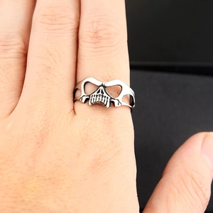 Macro shot of punk hollow skull ring with vintage silver finish on a finger
