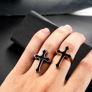 Close-up of gothic cross rings in gold and silver with black enamel on a model hand
