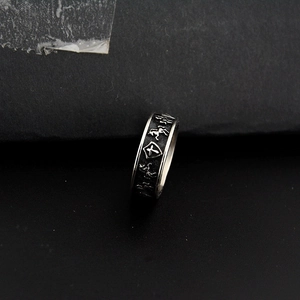 Macro shot of punk style horse and shield embossed patterns on silver titanium steel ring