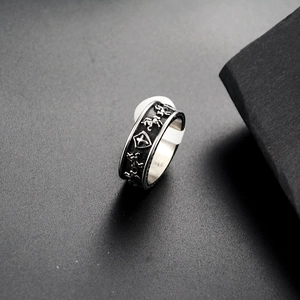 Detail of vintage silver punk ring featuring shield and horse reliefs on black texture