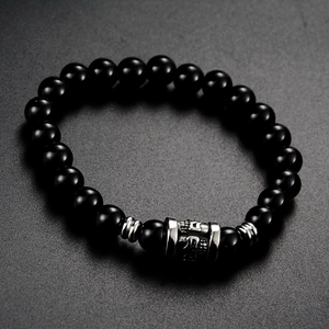 Detail view of black beaded bracelet with silver titanium steel engraved cylinder bead