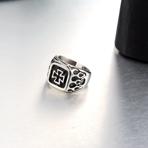 Detailed macro view of punk square steel ring featuring iron cross and flame relief