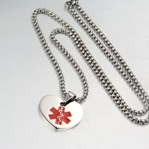 Close-up of heart-shaped medical alert pendant with red Star of Life and beaded chain