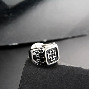 Macro detail of men's gothic square cross ring with flame relief on stone base