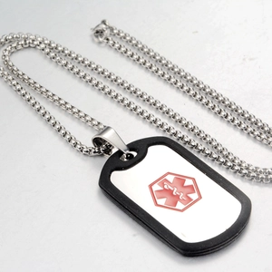 Detail of medical alert necklace featuring silver steel chain and red caduceus logo pendant