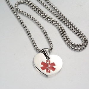 Macro shot of stainless steel heart necklace featuring a red Star of Life medical symbol