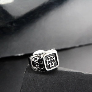 Detail of vintage silver square signet ring with gothic cross and flame relief pattern