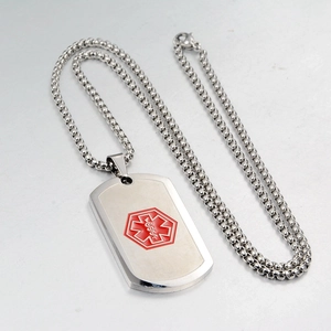 Macro detail of stainless steel medical ID tag with red Star of Life and beaded chain