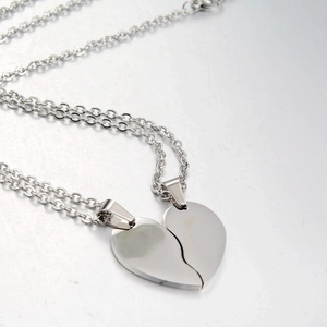 Detail of silver heart pendants for couples showing magnetic split heart design
