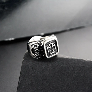 Macro detail of men's punk square ring with cross relief and flame side carvings
