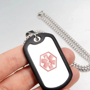 Detailed close-up of a medical ID tag with red caduceus star and black silicone bumper cover