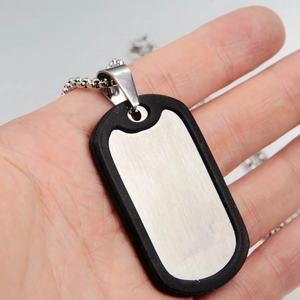 Macro detail of medical dog tag necklace featuring brushed steel finish and black silicone rim
