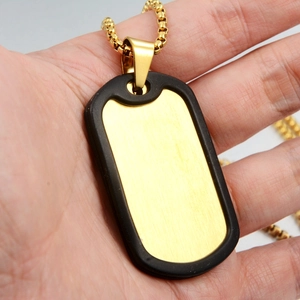 Detail showing the brushed gold finish of a medical alert tag with black rubber edge protector