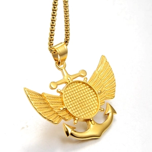 Collier avec pendentif ancre et ailes dorées avec chaîne à billes sur fond blanc