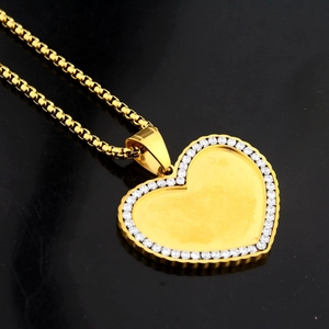 Dettaglio di una collana con medaglione a cuore dorato con cristalli e catena box