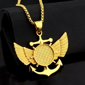 Vue macro d'un pendentif nautique doré avec ailes et ancre sur chaîne perlée