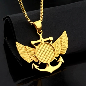 Détail macro du pendentif ancre avec ailes dorées sur une chaîne box noire