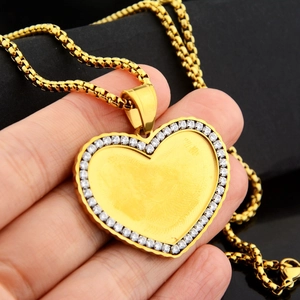 Macro di collana con medaglione a cuore dorato con bordi in zircone e catena spessa