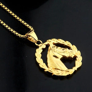 Détail d'un pendentif tête de cheval doré avec feuilles de laurier sur une chaîne maille