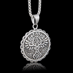 Macro detail of Tree of Life pendant with embossed texture on black background