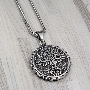 Macro detail of Tree of Life pendant with Celtic knot relief on stainless steel box chain