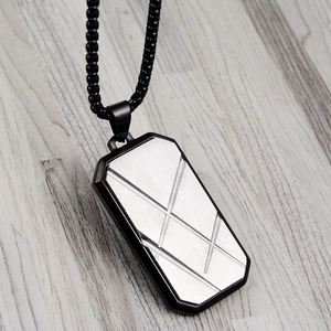 Macro detail of striped square pendant in black and silver steel on a bead chain