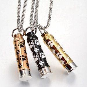 Detailed view of rose gold black and gold cylindrical pet cremation necklaces with paw prints