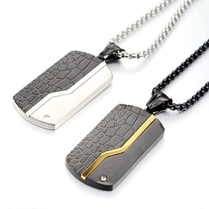 Detail view of steel dog tag necklaces with crocodile texture and inset diamond