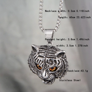 Detailed close-up of retro stainless steel tiger head pendant with orange gem eyes