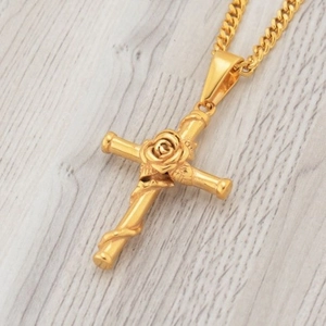 Golden rose cross necklace with cuban chain on wooden surface in 45-degree angle