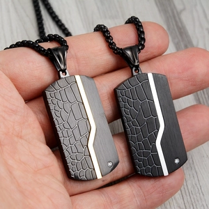 Detail of titanium steel dog tag pendants with crocodile texture and zircon inlay