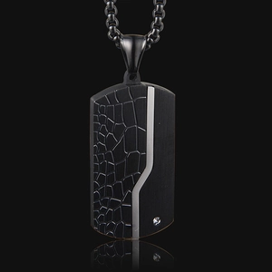 Detail of black military dog tag necklace with textured matte finish and single crystal