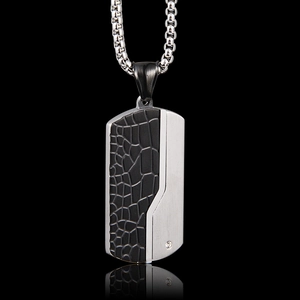 Detail of army dog tag pendant with black crocodile pattern, silver brushed metal and zircon