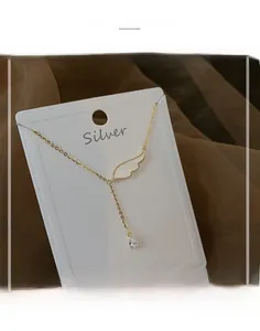 Détail du collier ailes d'ange dorées avec zircon en goutte sur une carte en argent S925