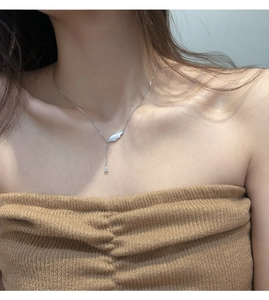 Détail du collier aile d'ange avec nacre et zircon tombant sur une chaîne argent