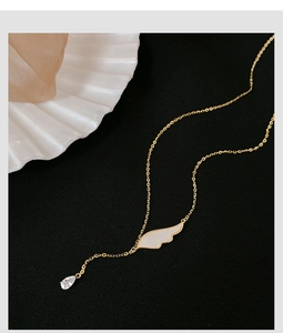 Détail du collier ailes d'ange dorées avec incrustation de nacre et goutte de zircon