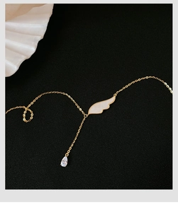 Détail du pendentif aile d'ange avec nacre blanche et zircon en forme de goutte
