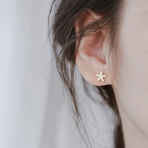 Boucles d'oreilles étoiles minimalistes en argent S925 avec zircons portées par un mannequin
