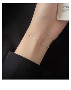 Detailed view of minimalist S925 sterling silver snake chain bracelet on a female wrist