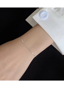 Delicate S925 sterling silver snake chain bracelet worn on wrist with white shirt cuff