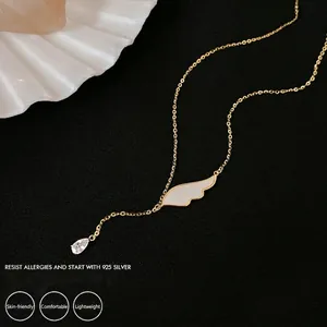 Collier élégant en argent 925 doré avec pendentif aile et zircon sur fond noir mat