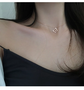 Nahaufnahme von Schmetterlingsanhänger in Roségold mit Zirkonia auf dem Schlüsselbein